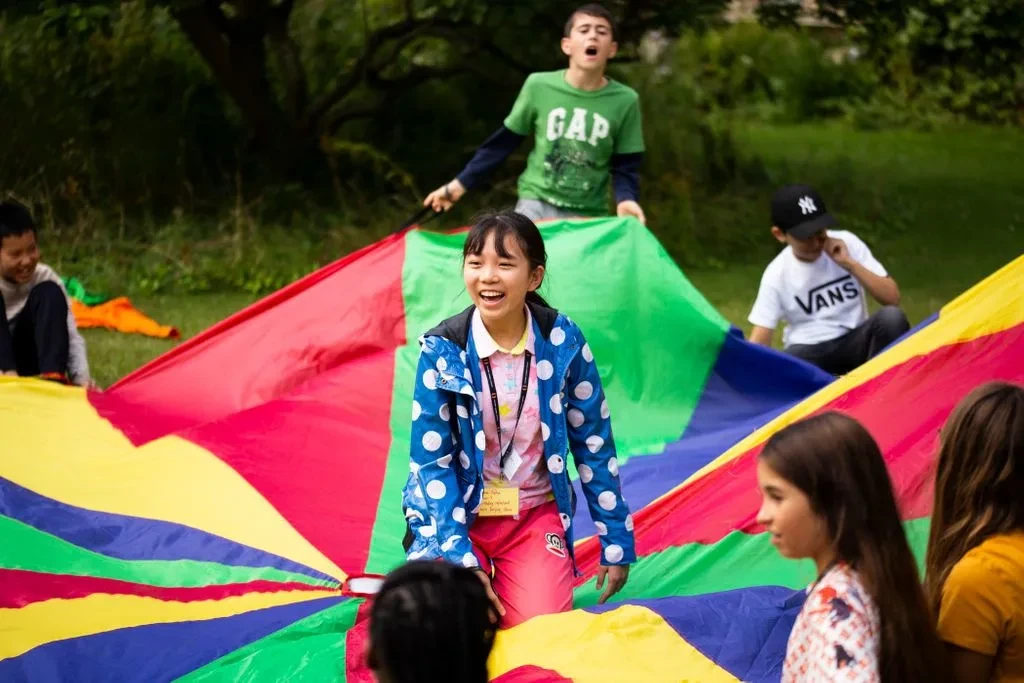Students participating in parachute activity outside