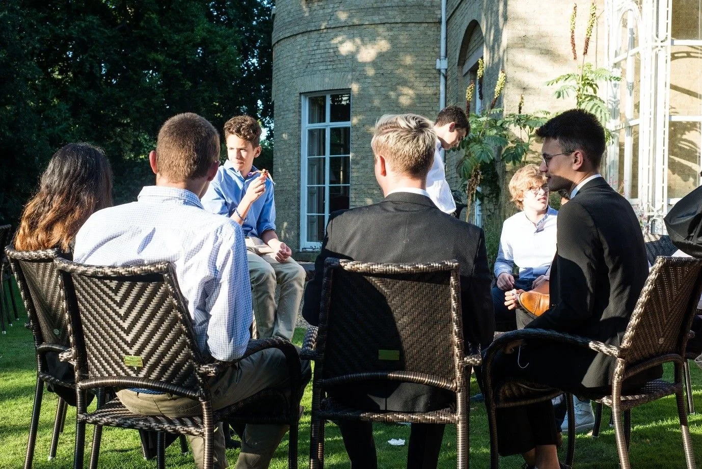 Students sitting in a circle outside socialising